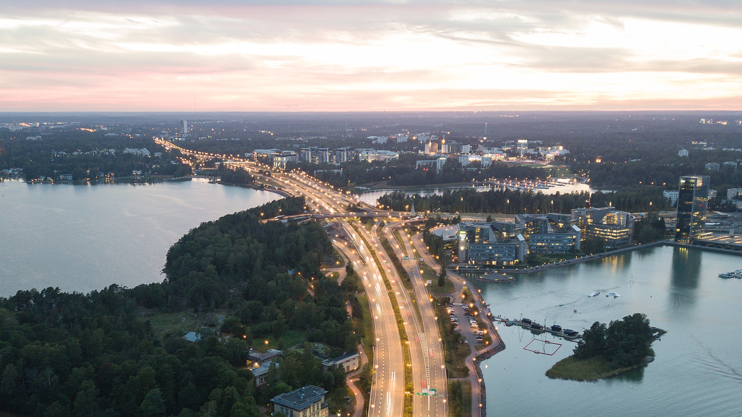 Valaistu Länsiväylä kuvattuna ylhäältäpäin kesäillan hämärässä.