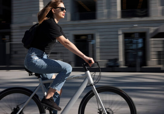 Henkilö pyöräilemässä kaupungissa.