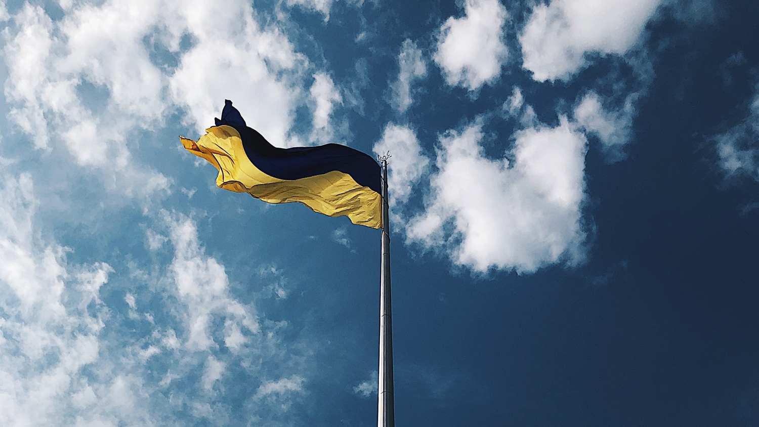 Ukrainan lippu salossa, taustalla taivas.